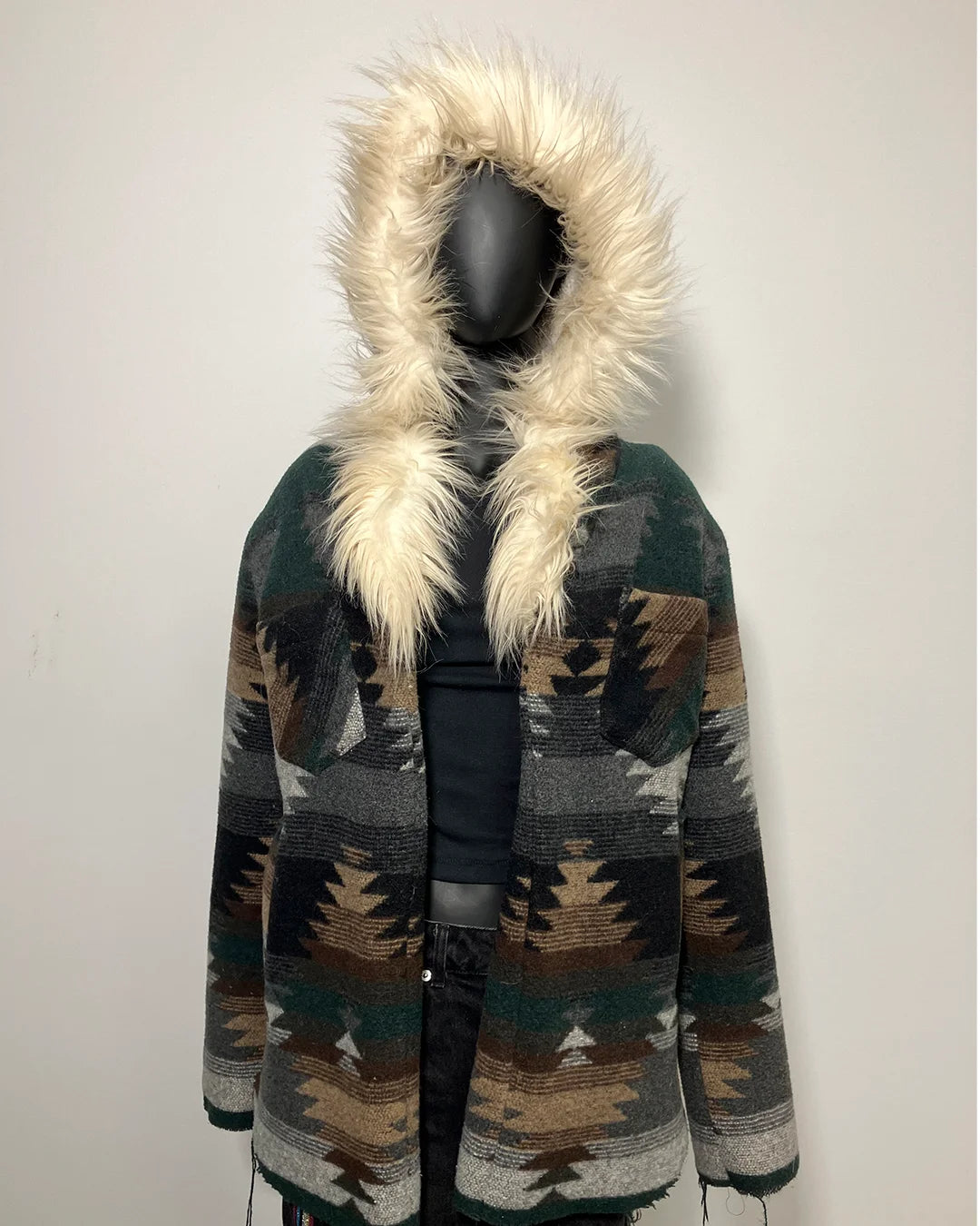 Patterned coat with fur-lined hood on a mannequin against a white background