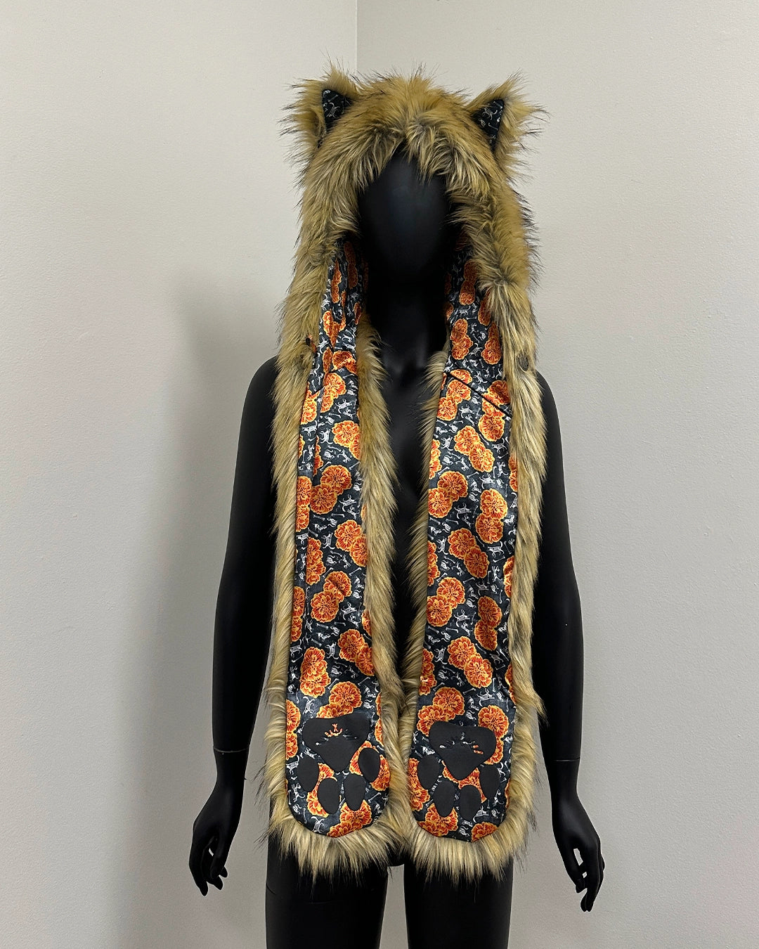 Mannequin wearing a fur-lined hood with cat ears and a patterned scarf 