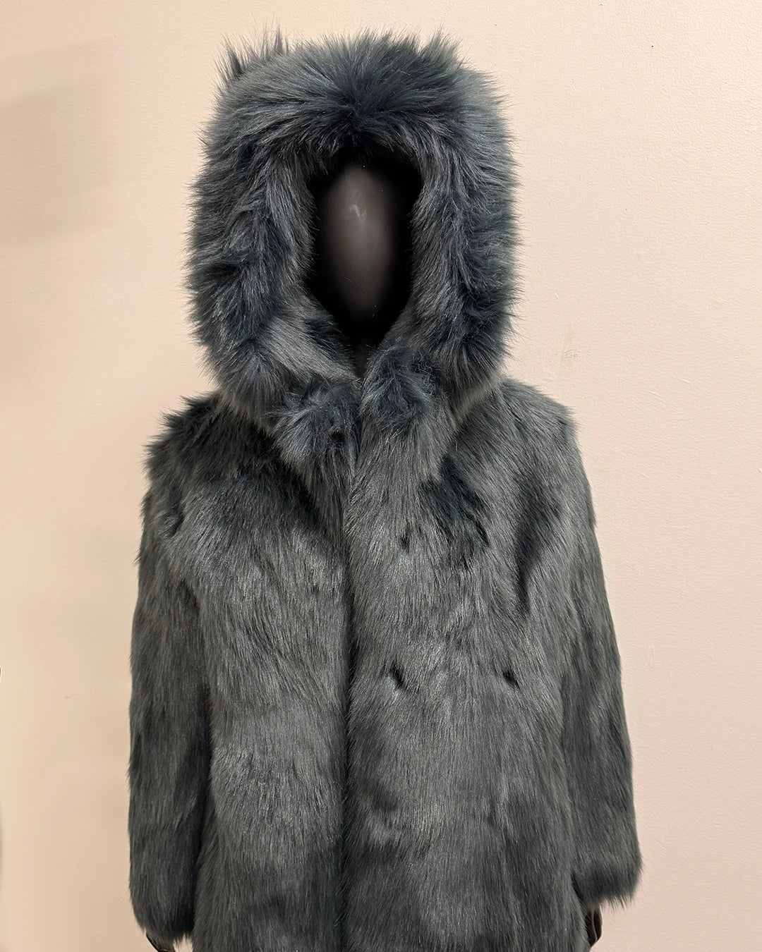Gray/blue fake fur coat with hood on a beige background