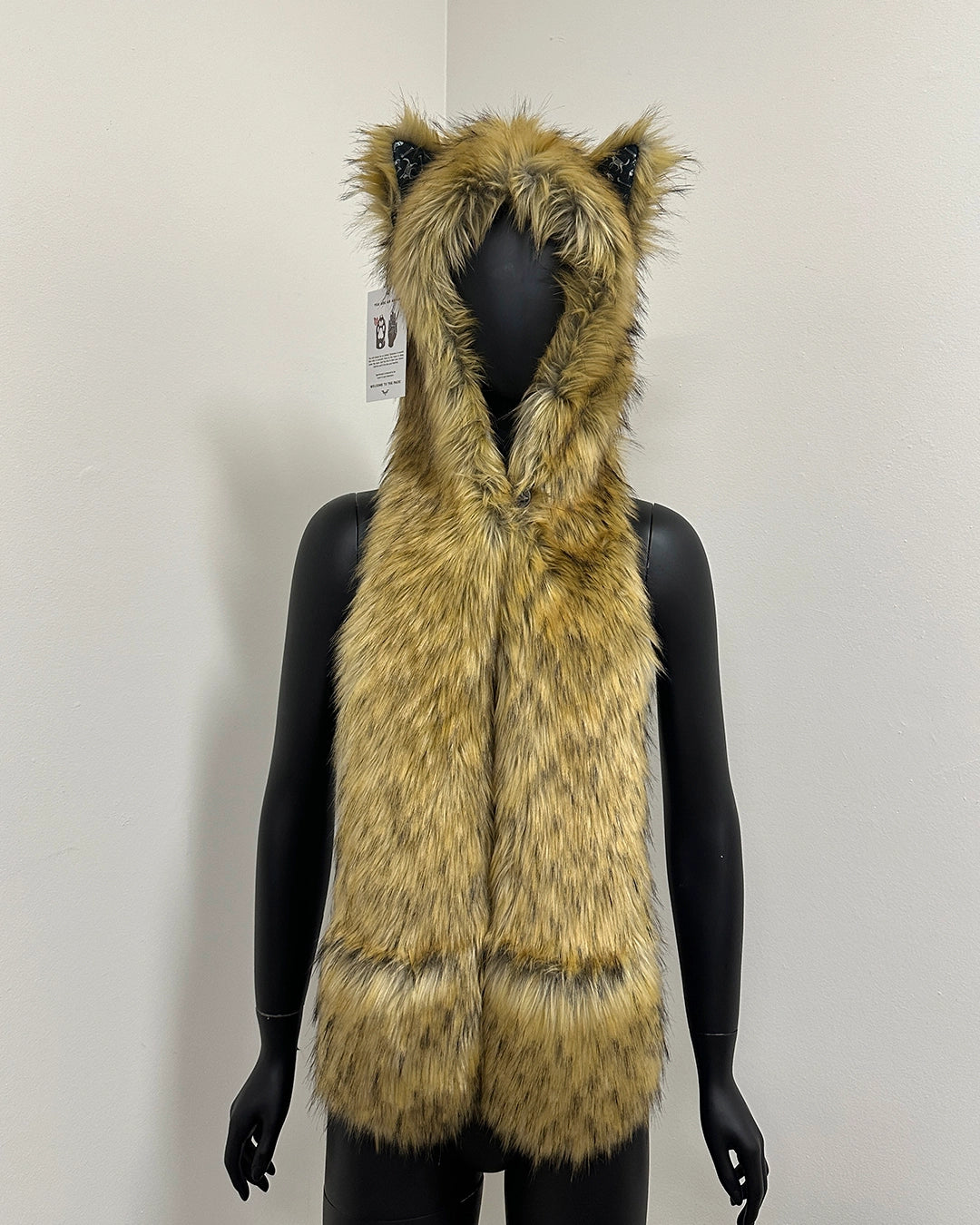 Mannequin wearing a fur-lined hood with cat ears and a patterned scarf 