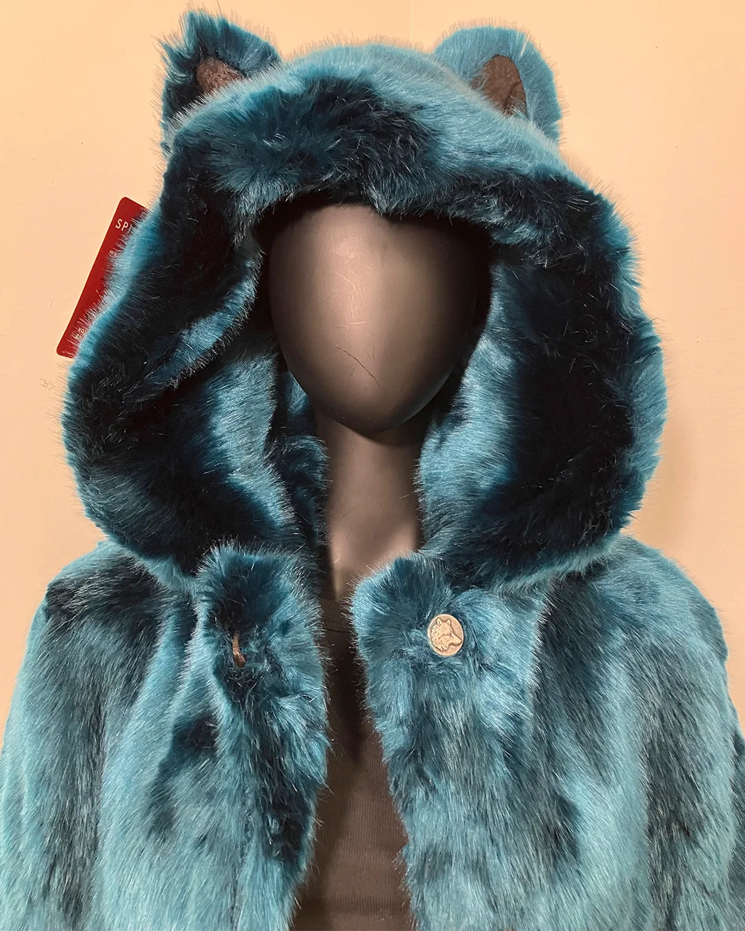 Blue faux fur coat with hood on a beige background, showing up close photo of the plush fake fur & oversized hood