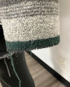 Close-up of a textured fabric with green trim on a mannequin.