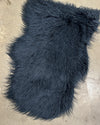 Dark blue shaggy fur rug on a concrete floor
