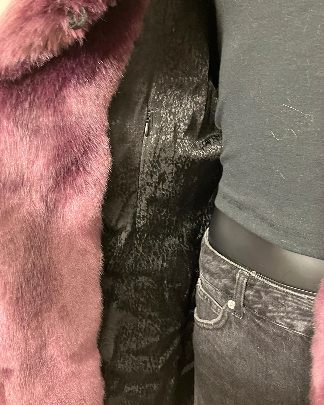 Close-up of a mannequin wearing a light lavender faux fur coat, showing the inner black faux-snakeskin lining in a poly-rayon, and gray pants.
