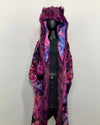 Mannequin wearing a long, colorful tiedye faux fur robe-coat with a hood on a white background