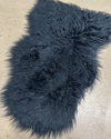 Dark blue fluffy faux fur rug on a concrete floor