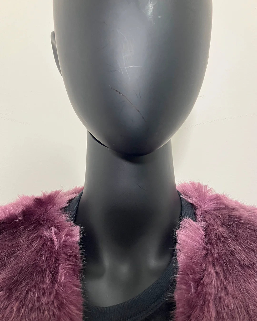 close up photo of the purple faux fur sewn into the seam new the neck line on both sides.