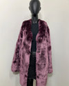 Mannequin wearing a purple faux fur coat against a white background