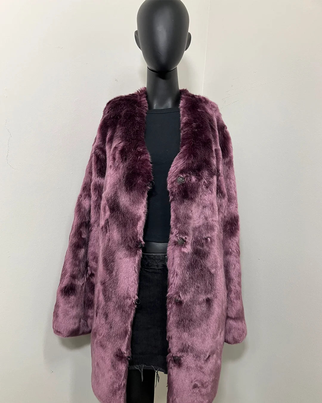 Mannequin wearing a purple faux fur coat against a white background
