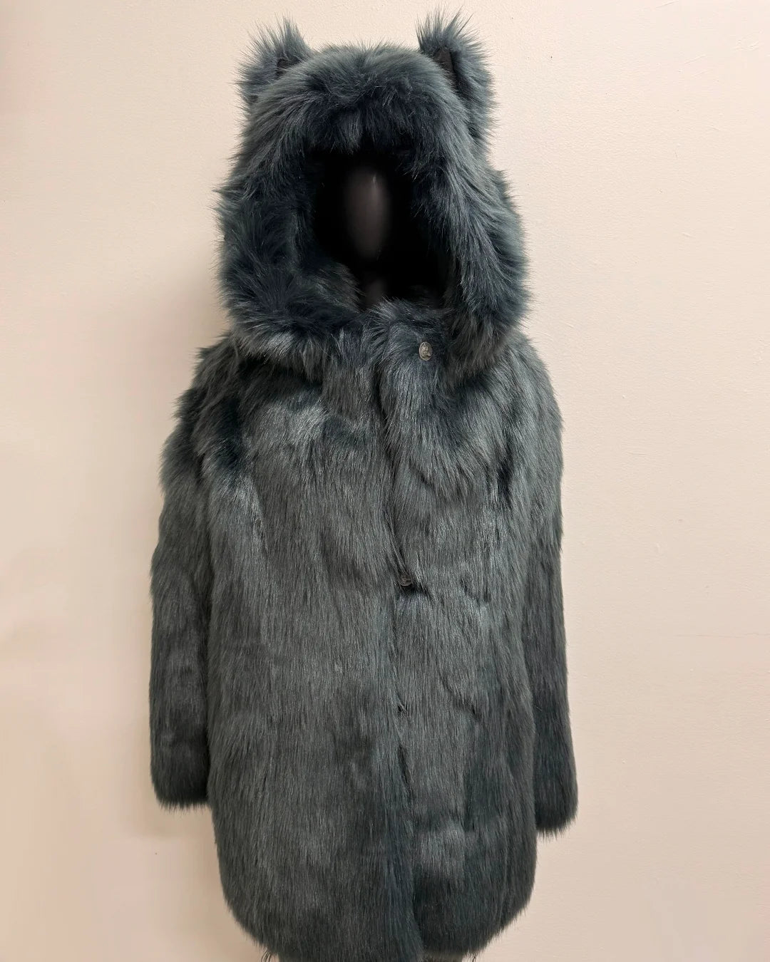 Dark gray/blue fake fur coat with hood on a beige background