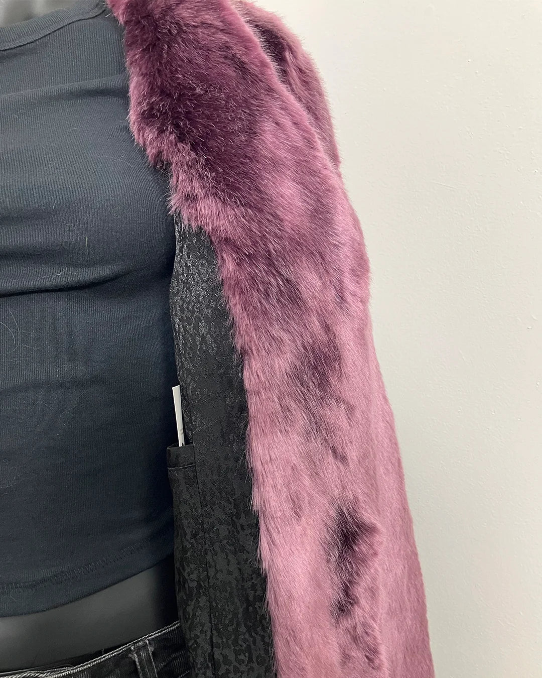 Close up photo of the light lavender purple faux fur and black snakeskin lining + inner welt pocket.