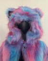 Mannequin wearing a colorful fake fur coat with pink and blue hues on a plain background