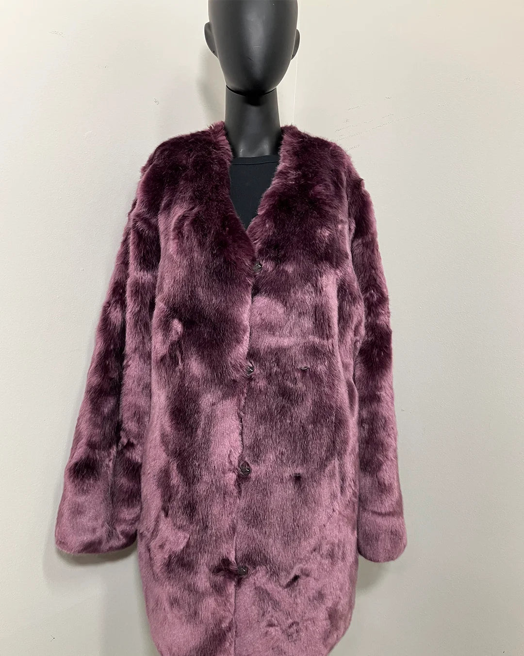 Purple faux fur coat on a mannequin against a white background