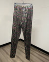 Metallic snakeskin print leggings hanging on a clear plastic hanger against a plain off-white wall with a wood-look floor.