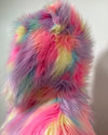 Close Up Photo of the Multicolored fluffy fake fur with a gradient of pink, yellow, and blue on a plain background.