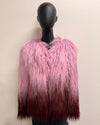 Mannequin wearing a pink and maroon ombre faux fur vest against a beige background
