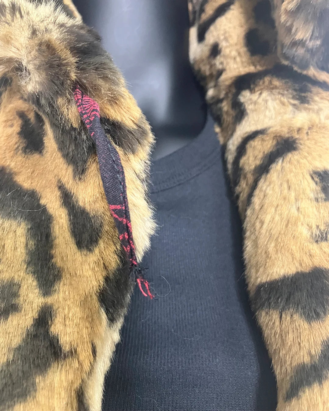 close-up photo of the broken button loop on the luxe faux fur jaguar coat. SpiritHoods Online Sample Sale Style: Luxe Classic Faux Fur Coat in Jaguar Size X-SMALL.