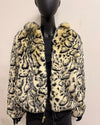 Leopard print fake fur coat on a mannequin against a plain background