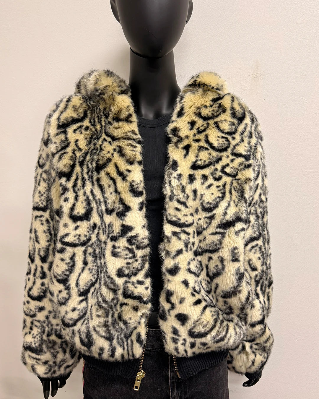 Leopard print fake fur coat on a mannequin against a plain background