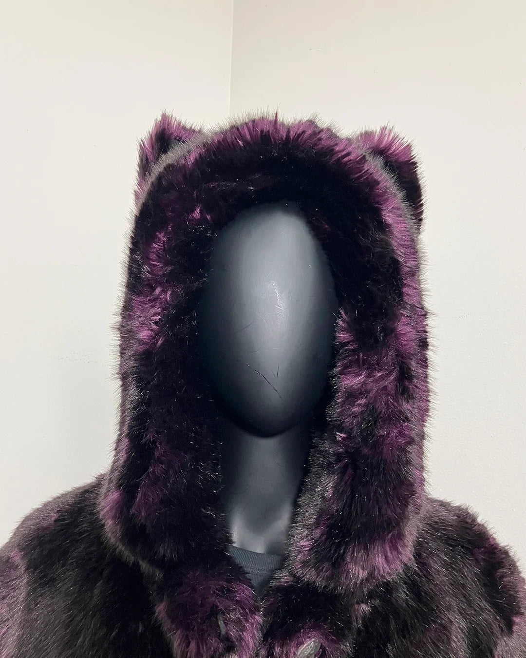 Close Up photo of the Purple plush faux fur hood on a mannequin against a white background