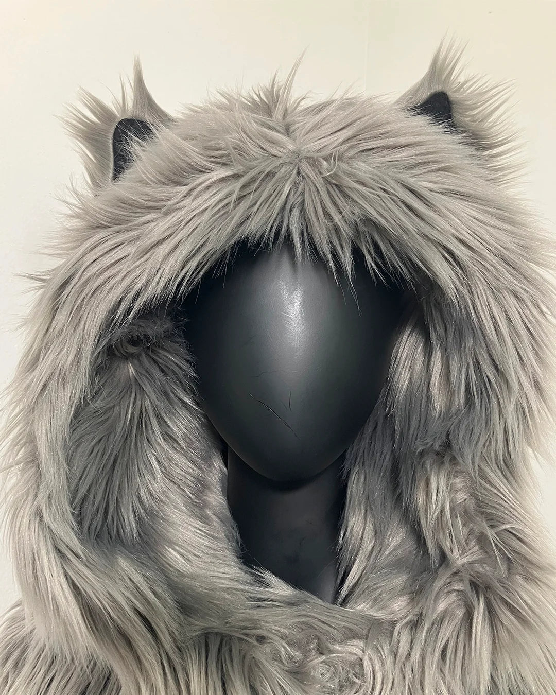 Mannequin wearing an oversized hood with k-9 ears,  on a plain background