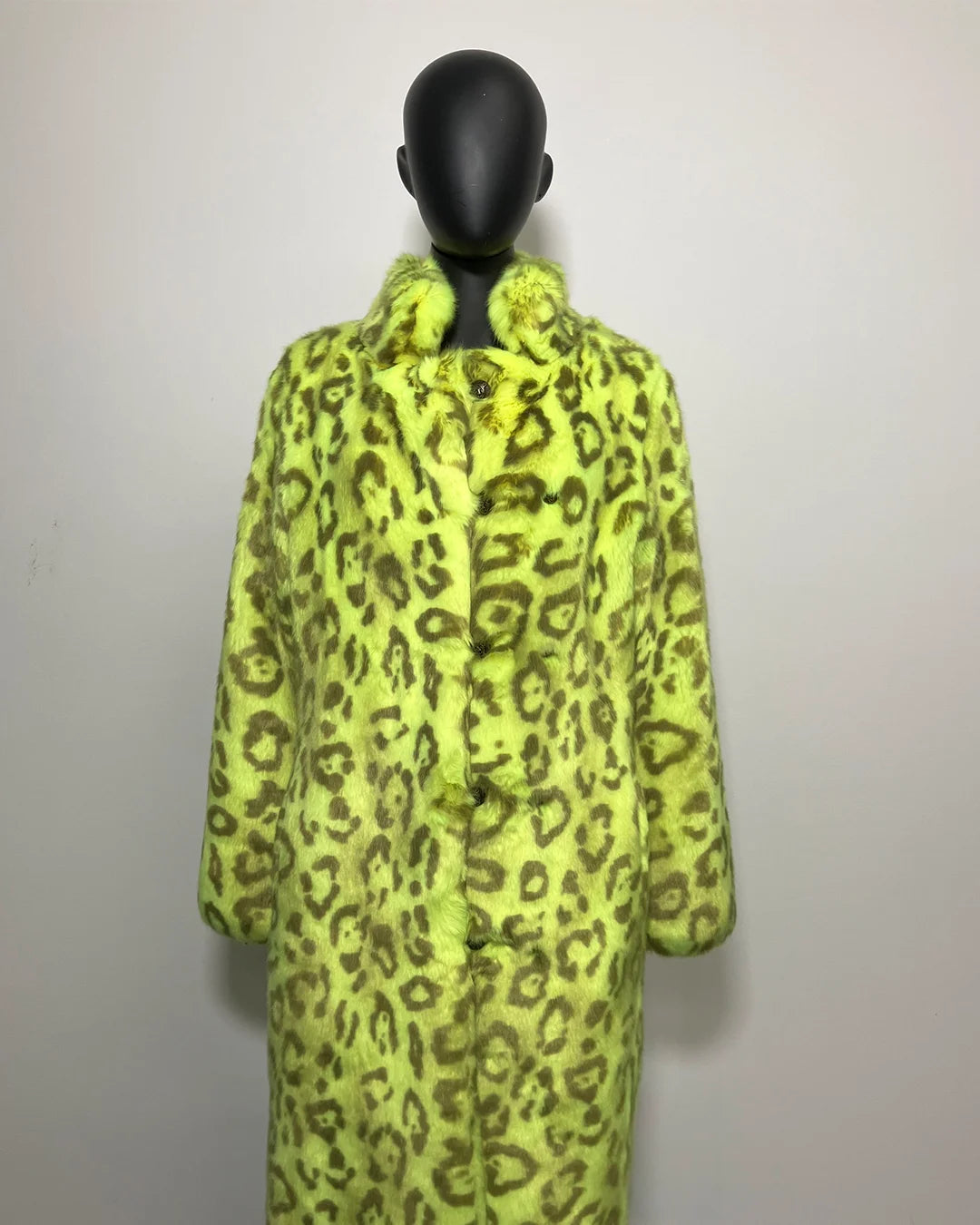 Mannequin wearing a bright yellow leopard print coat against a plain background