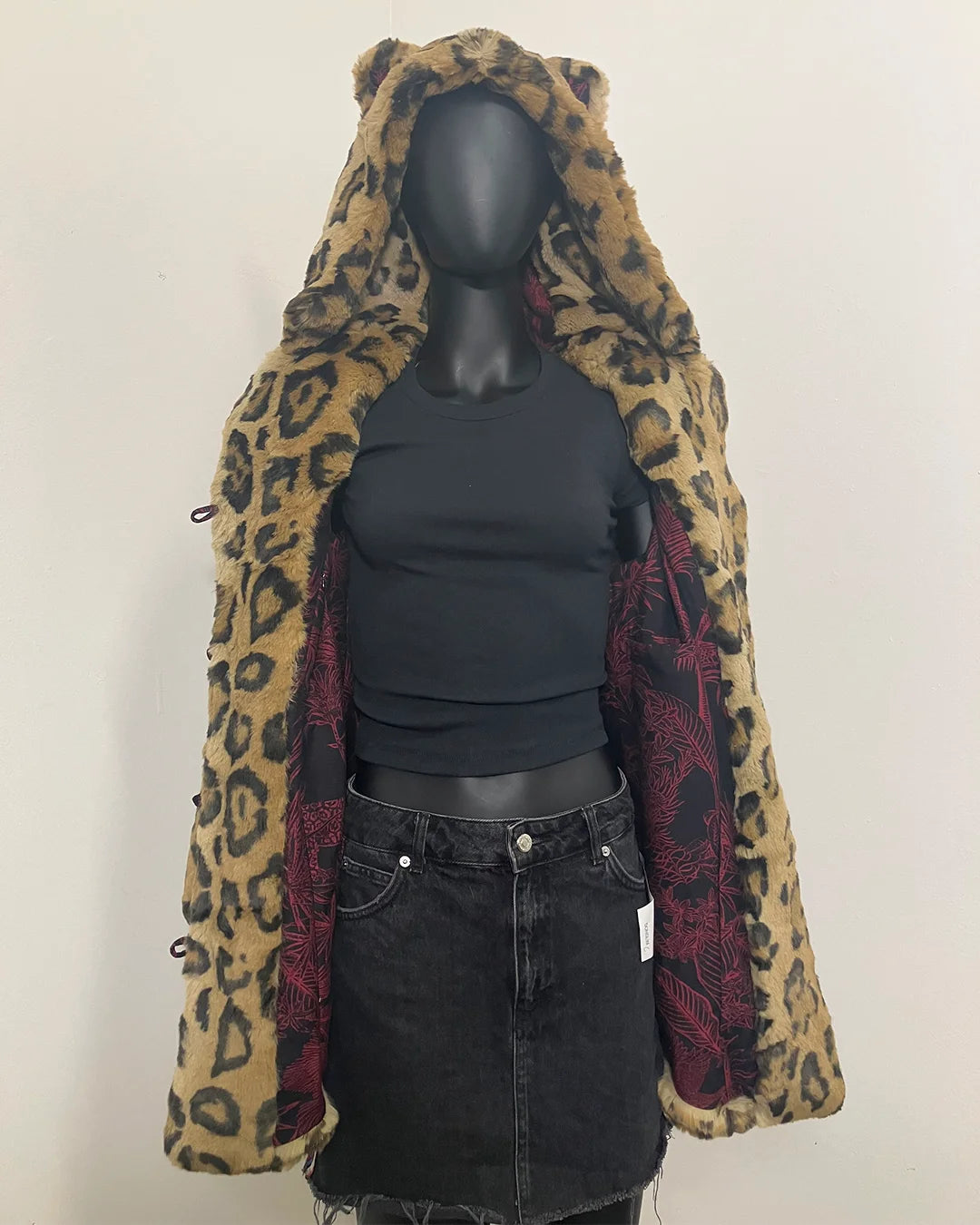 Mannequin wearing a jaguar print hooded fake fur coat with ears with a plain background. SpiritHoods Online Sample Sale Style: Luxe Classic Faux Fur Coat in Jaguar Size X-SMALL.