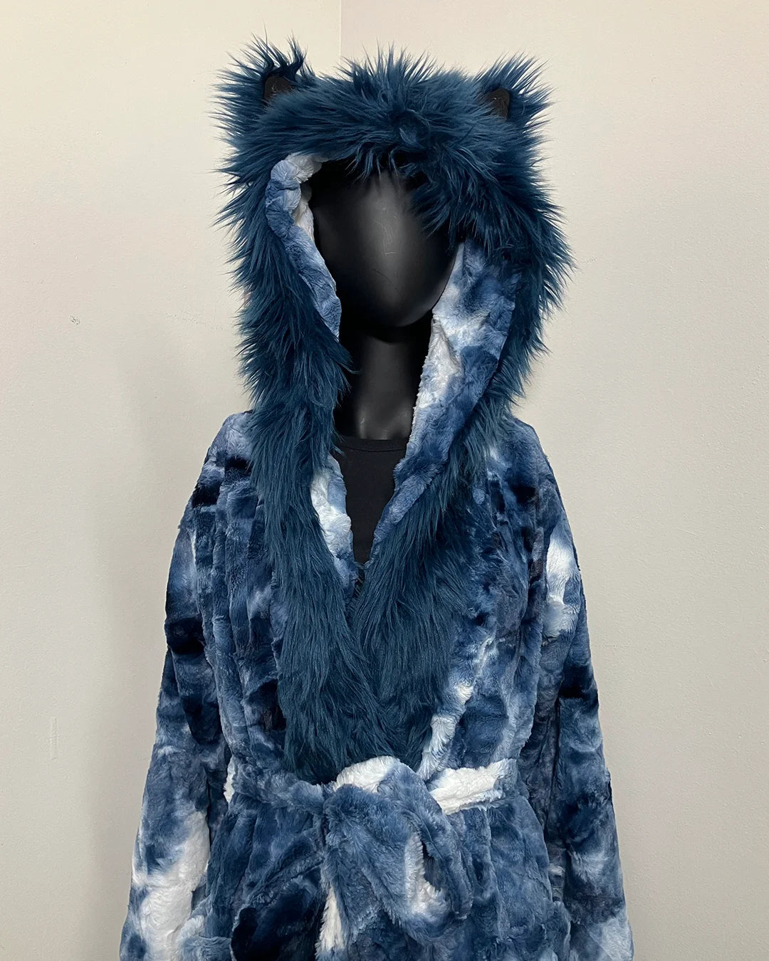 Blue tie-dye robe with wolf ears on a mannequin against a plain background