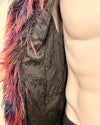 Close-up of a textured fabric with colorful fringe and a neutral background