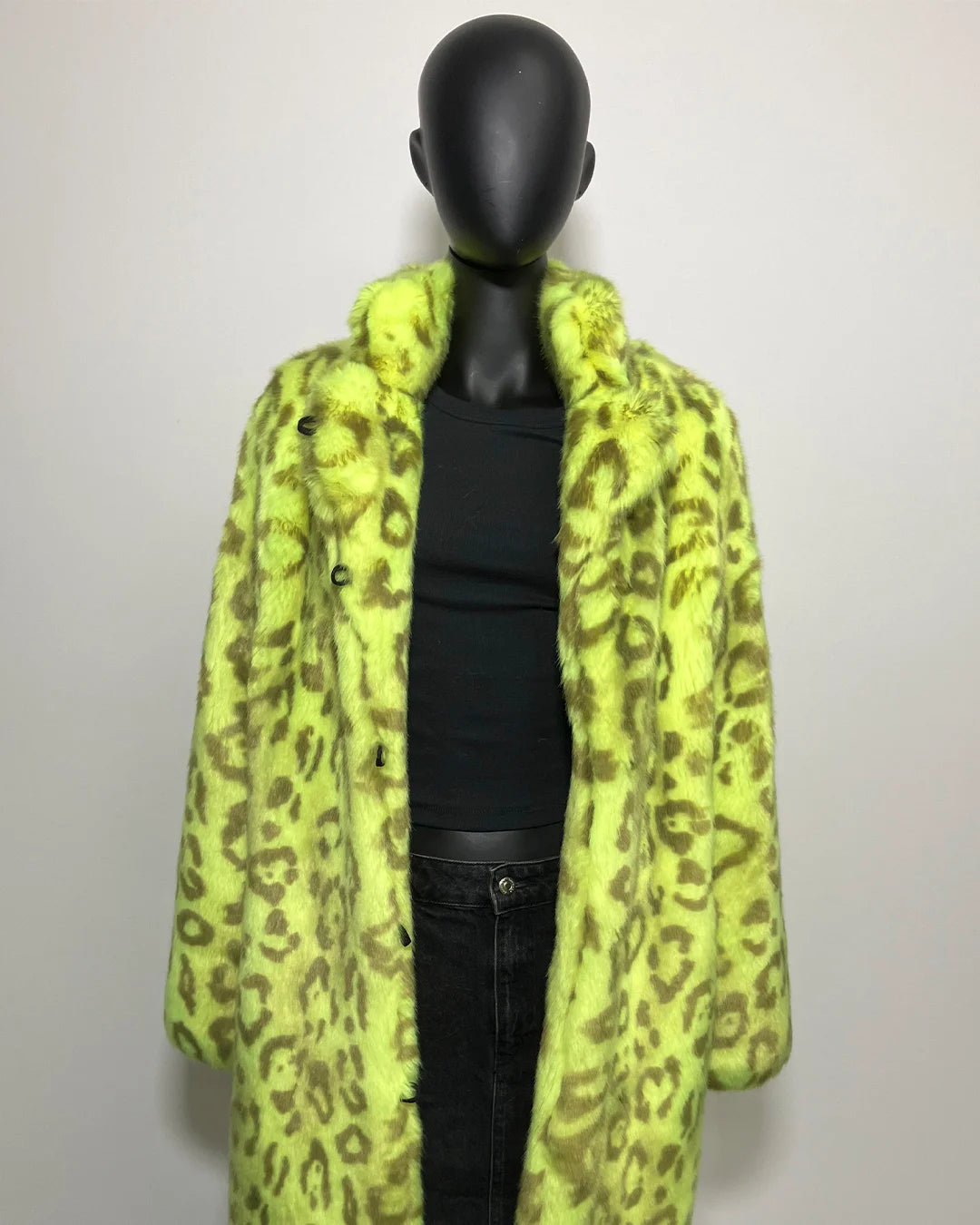 Mannequin wearing a bright yellow leopard print coat against a plain background