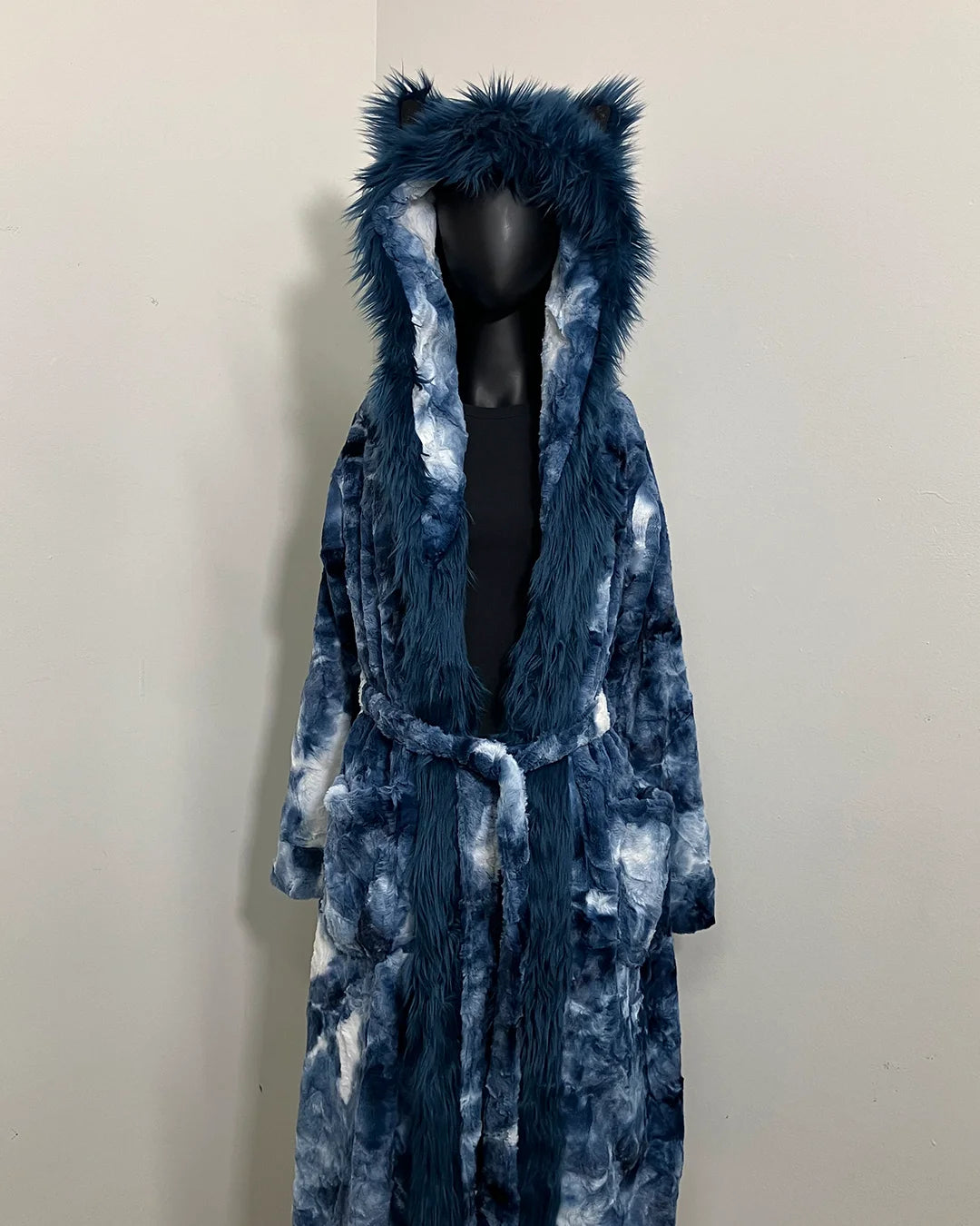 Blue tie-dye robe with fake fur hood on a mannequin against a plain background