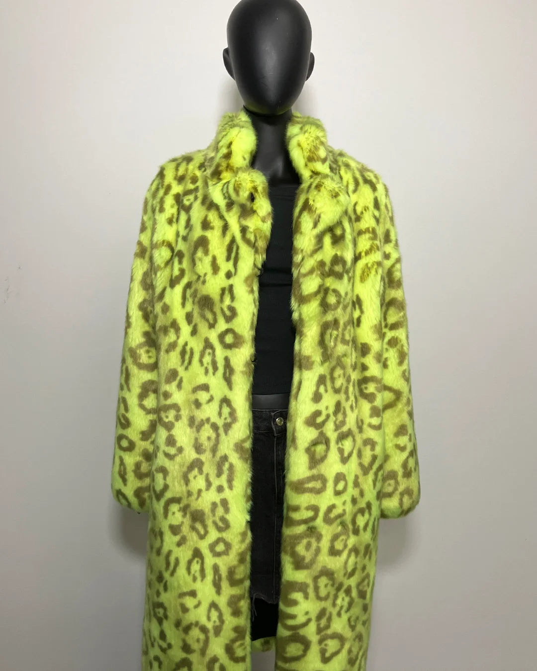 Mannequin wearing a bright yellow leopard print coat against a plain background