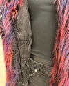 Person wearing a dark gray distressed alpaca inspired faux fur jacket with colorful fur trim on a plain background