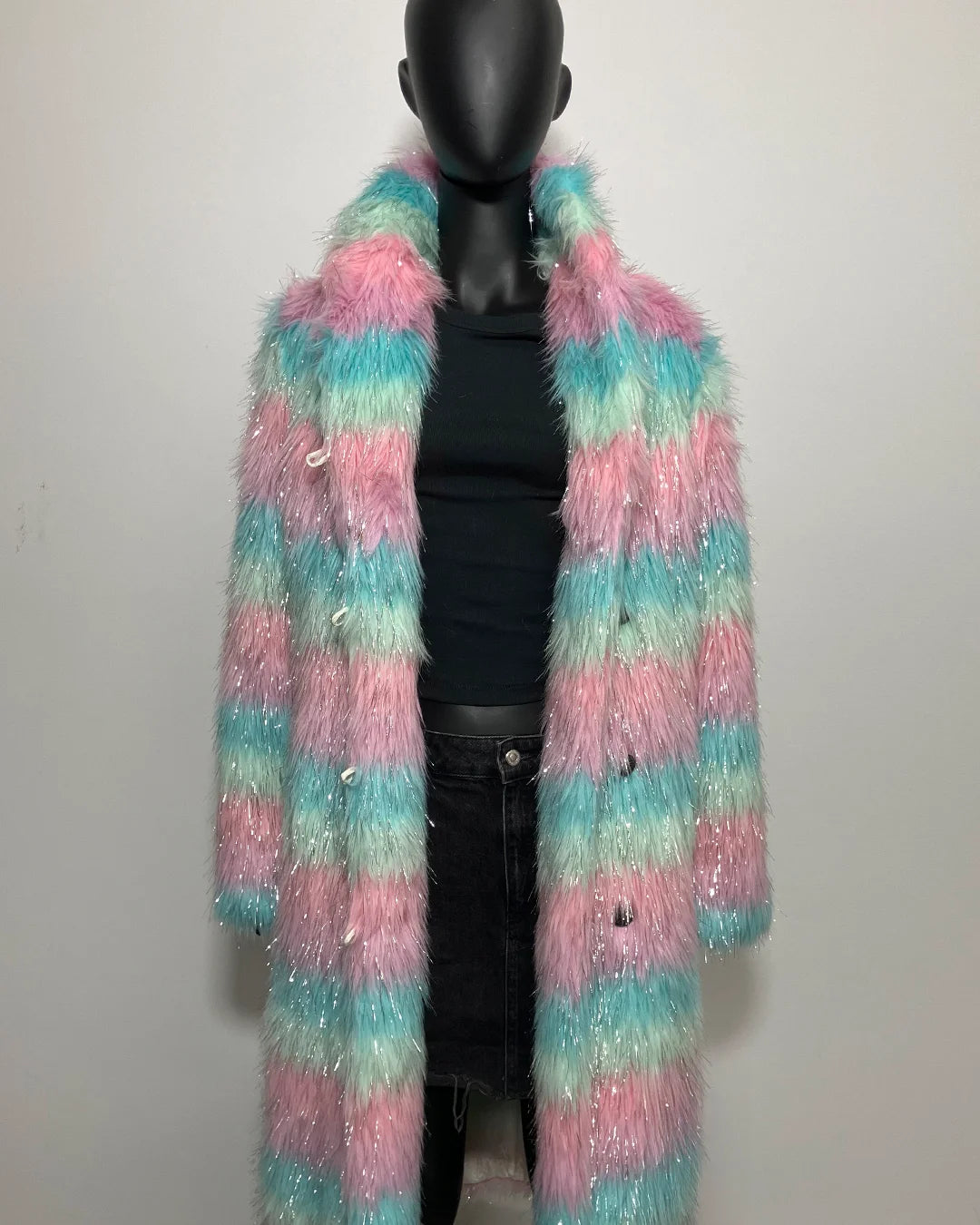 Multicolored fluffy fake fur coat on a mannequin against a white background
