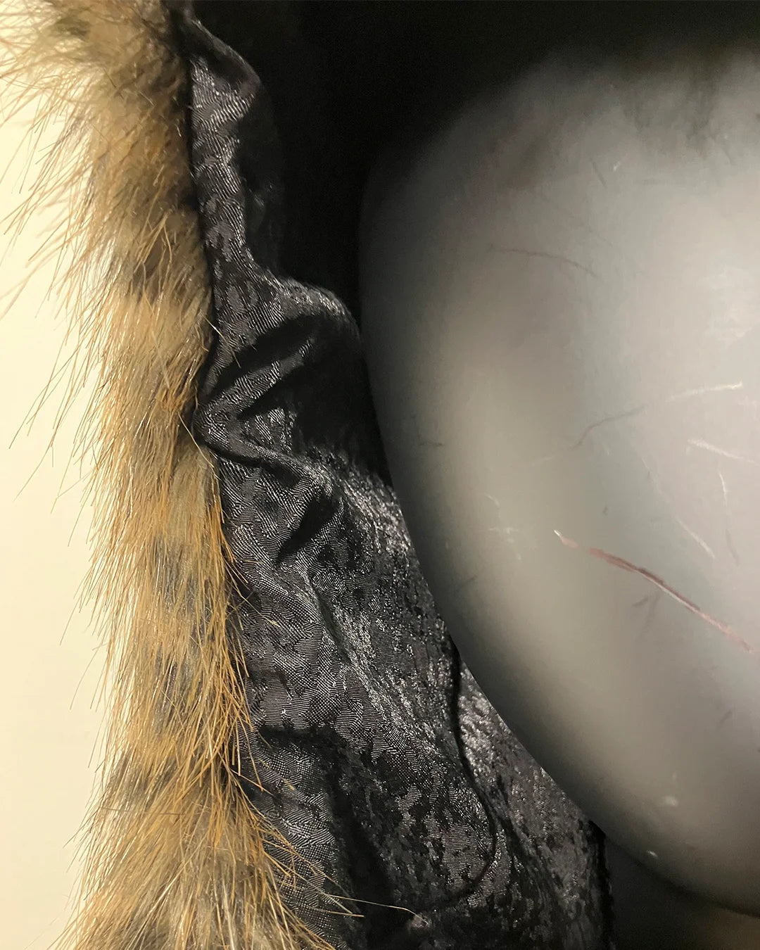 Close-up of a textured fabric with fur trim. Showing slight rusching in inner liner, on wearer's right side where the faux fur meets the inner liner. SpiritHoods Online Sample Sale Savannah Cat Classic Faux Fur Bomber Jacket in Size Medium