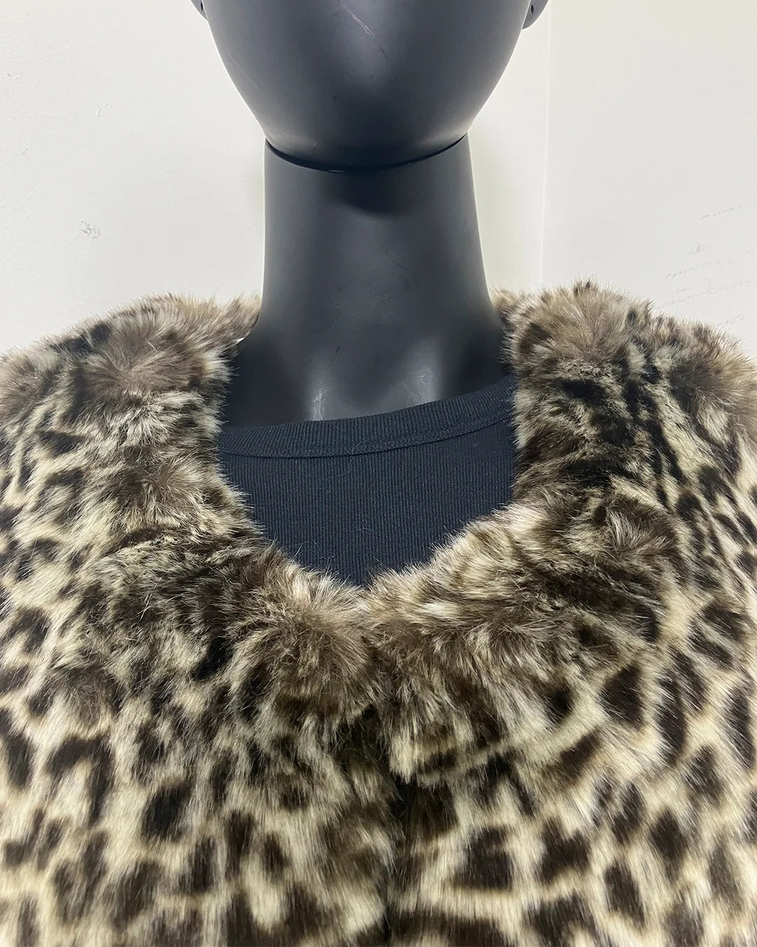 Mannequin wearing a leopard print fake fur coat against a white background