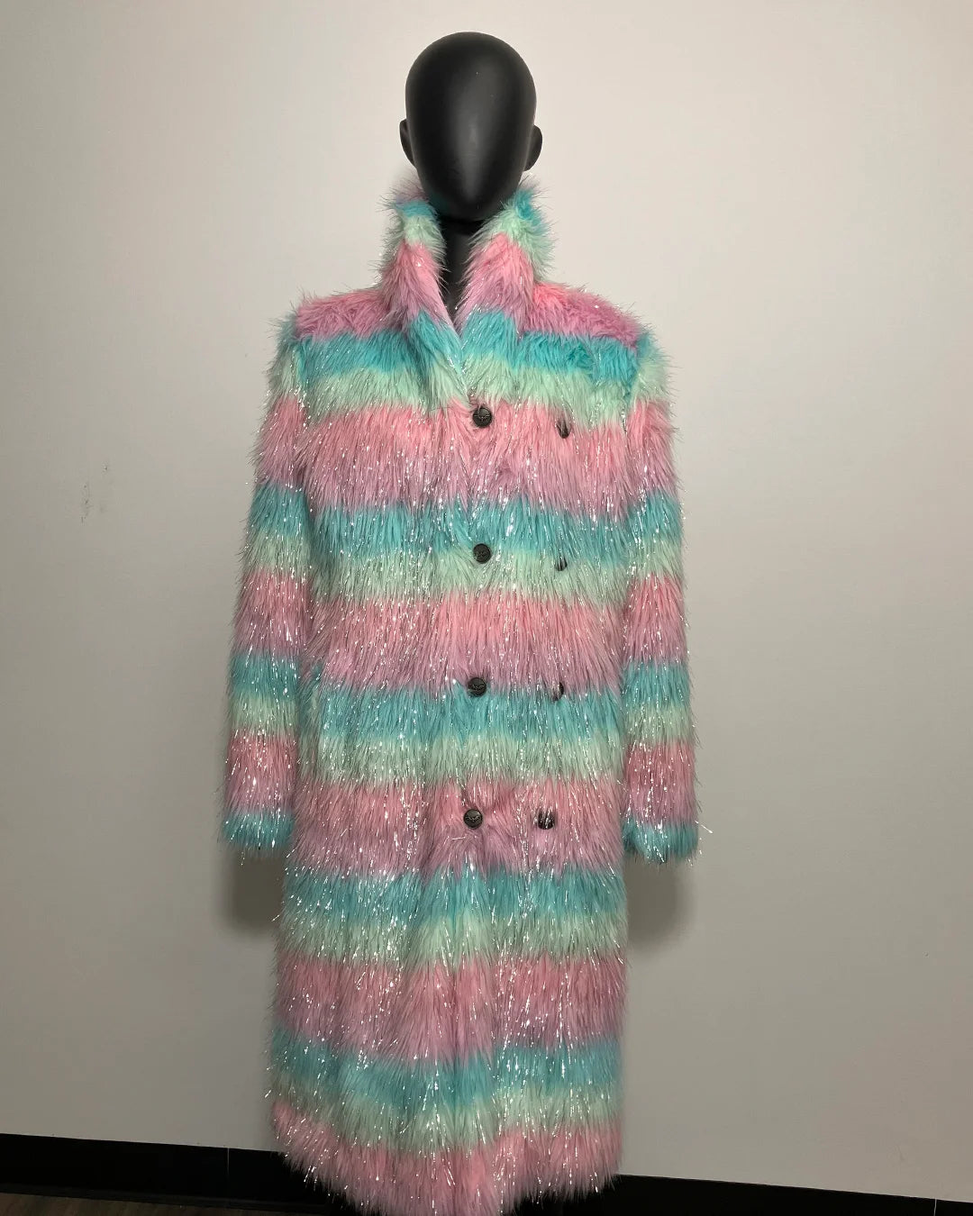 Multicolored striped faux fur coat on a mannequin against a plain background