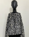 Leopard print sweater on a mannequin against a white background