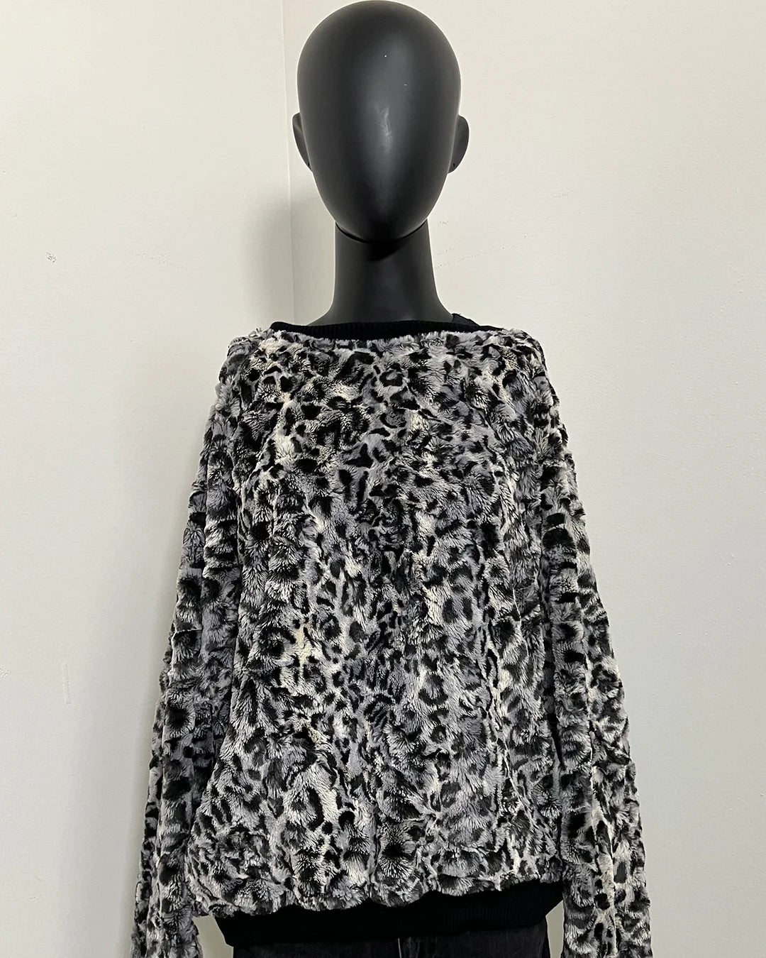 Leopard print sweater on a mannequin against a white background