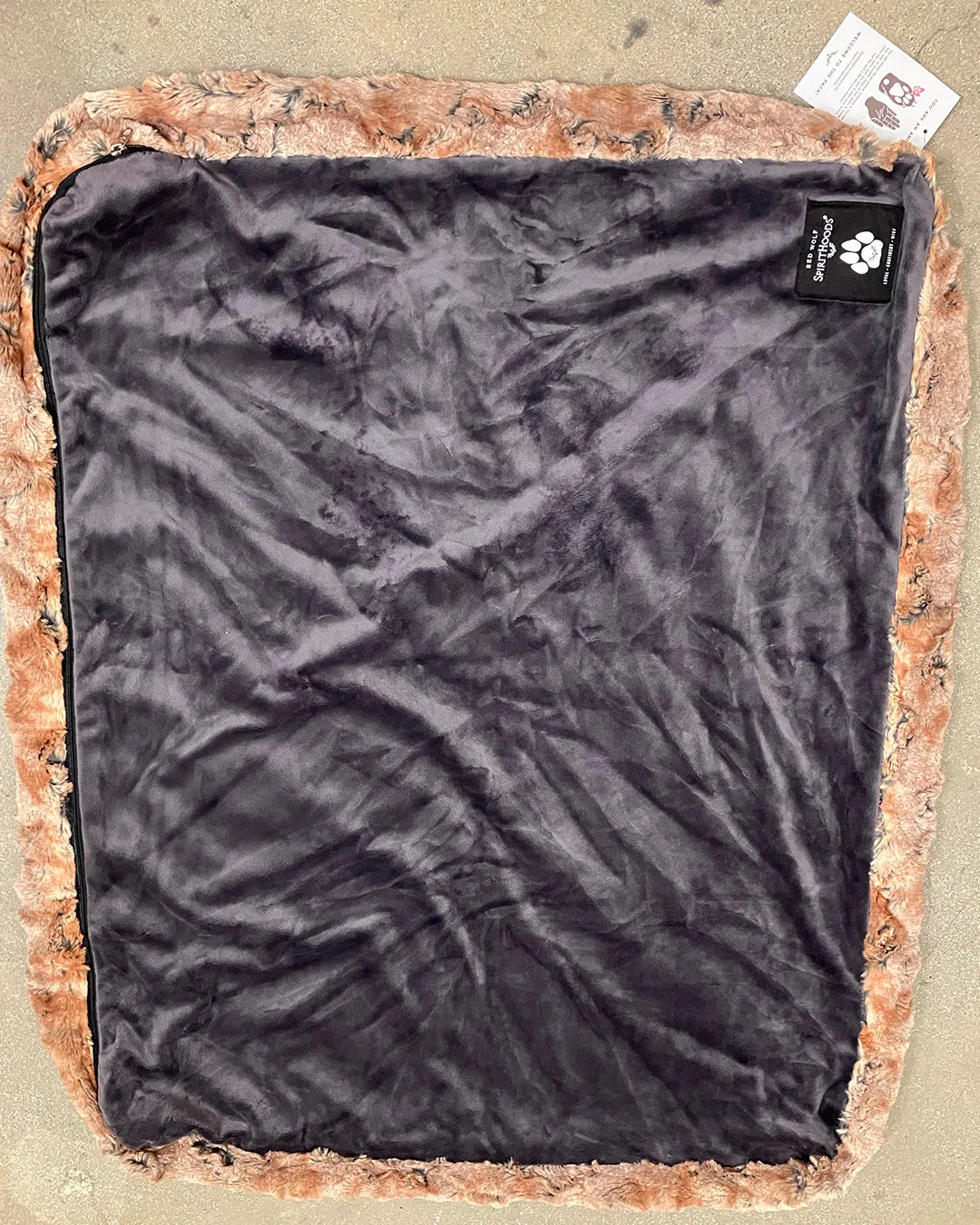 Black lining on red wolf pet bed  on a beige surface