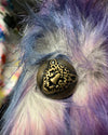 Decorative Leopard Face Button with intricate design on a fluffy, multicolored fabric background