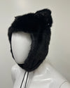 Black fur hat with decorative bow on a mannequin head 