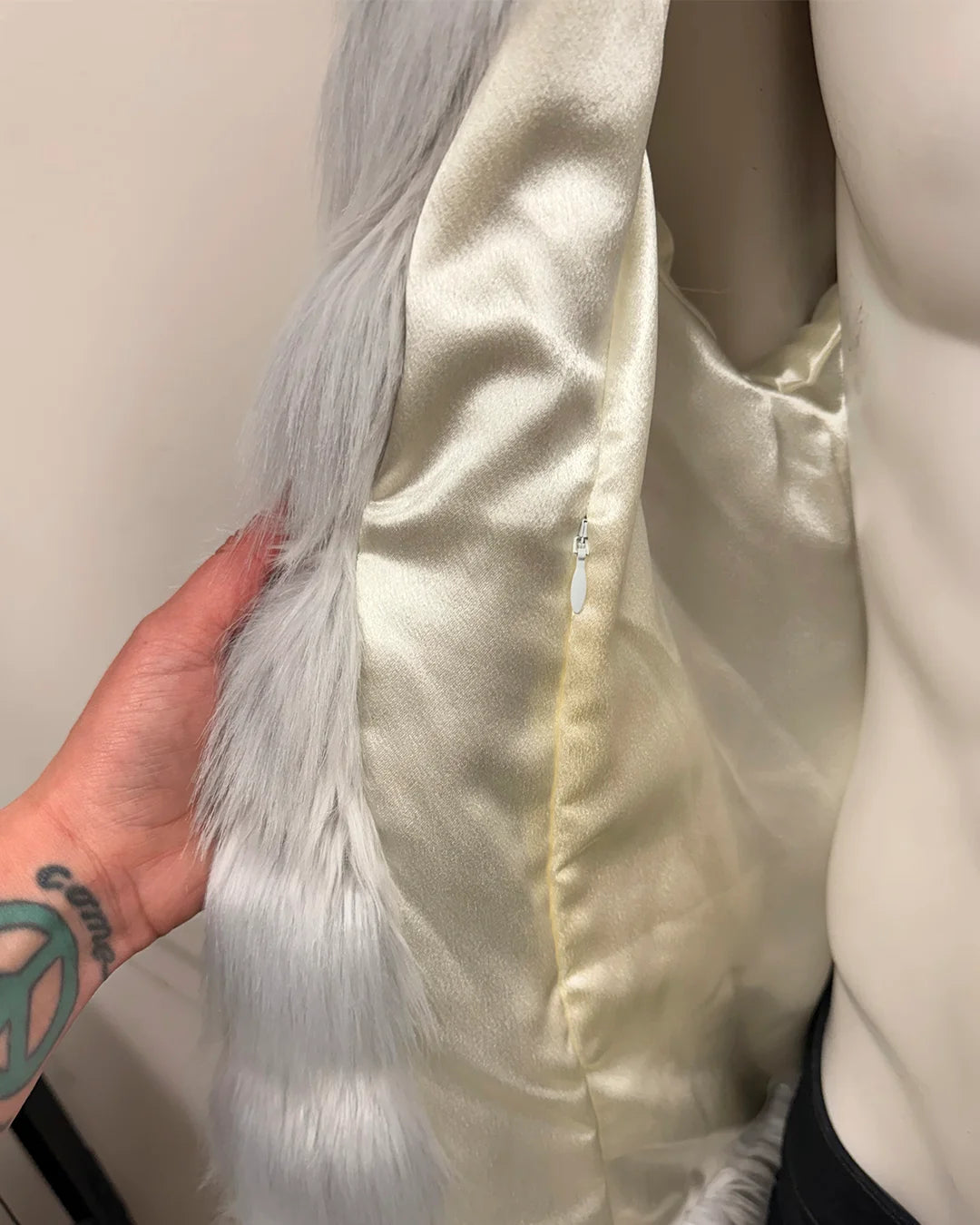 Close-up of a person showing the inner zipper pocket on the Tundra Fox bomber jacket inner lining