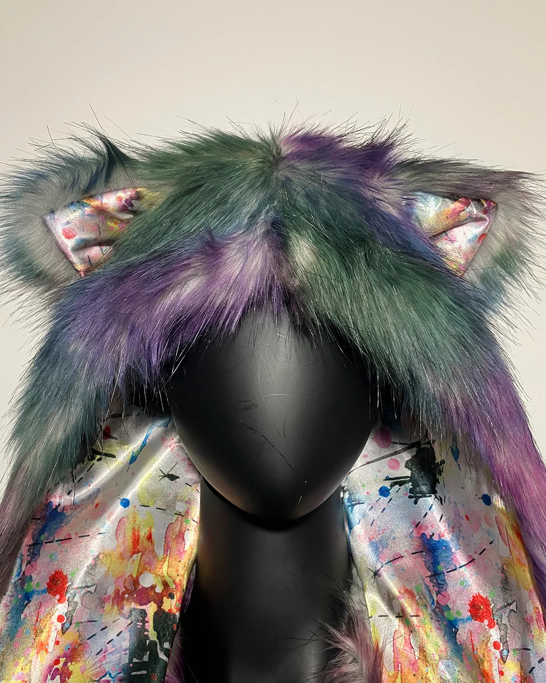 Multicolored faux fur SpiritHood Hood with decorative bows on a mannequin head against a plain background
