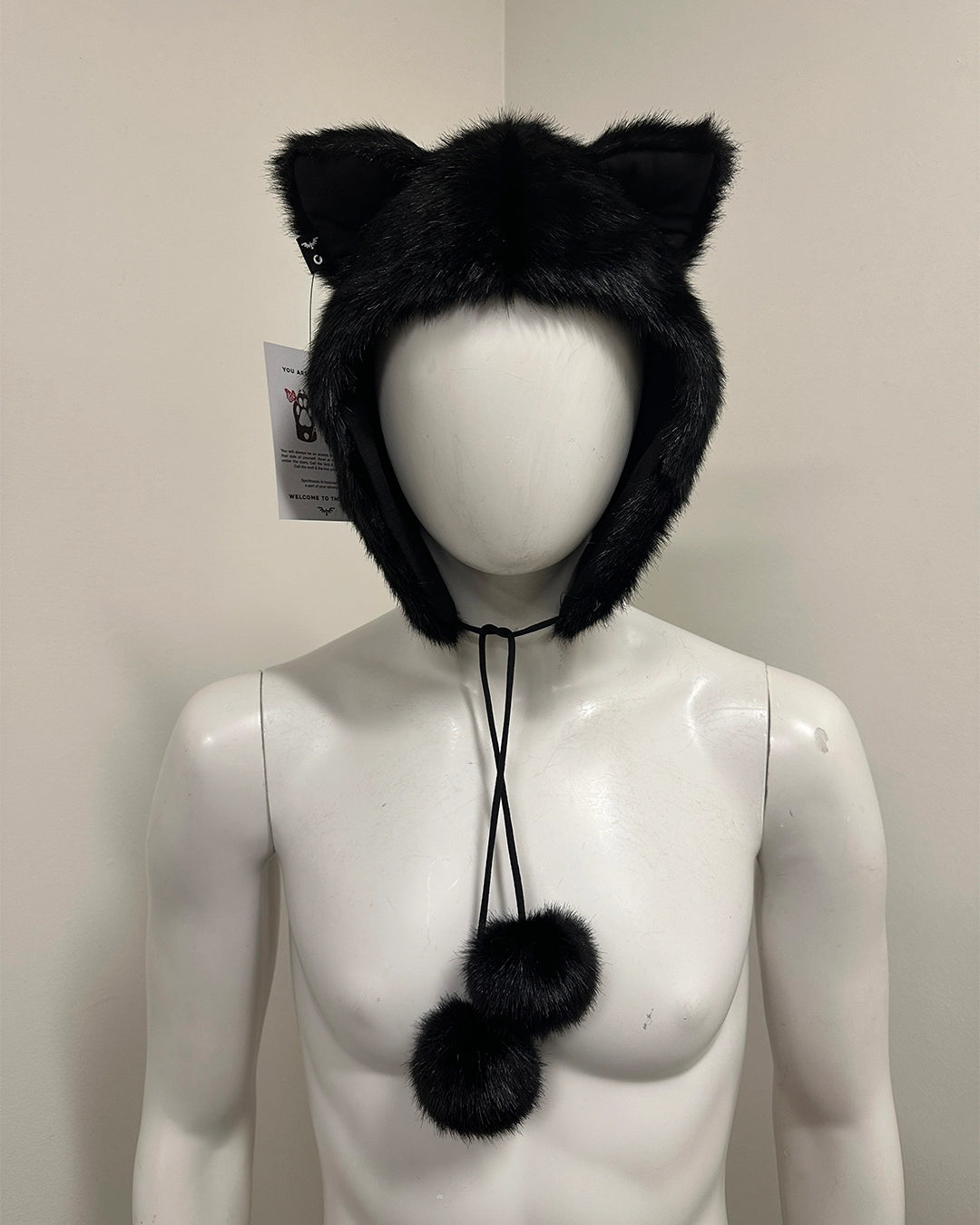Black faux fur cat ear hat on a mannequin with a neutral background