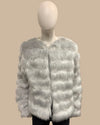 Mannequin wearing a light gray fake fur jacket on a beige background