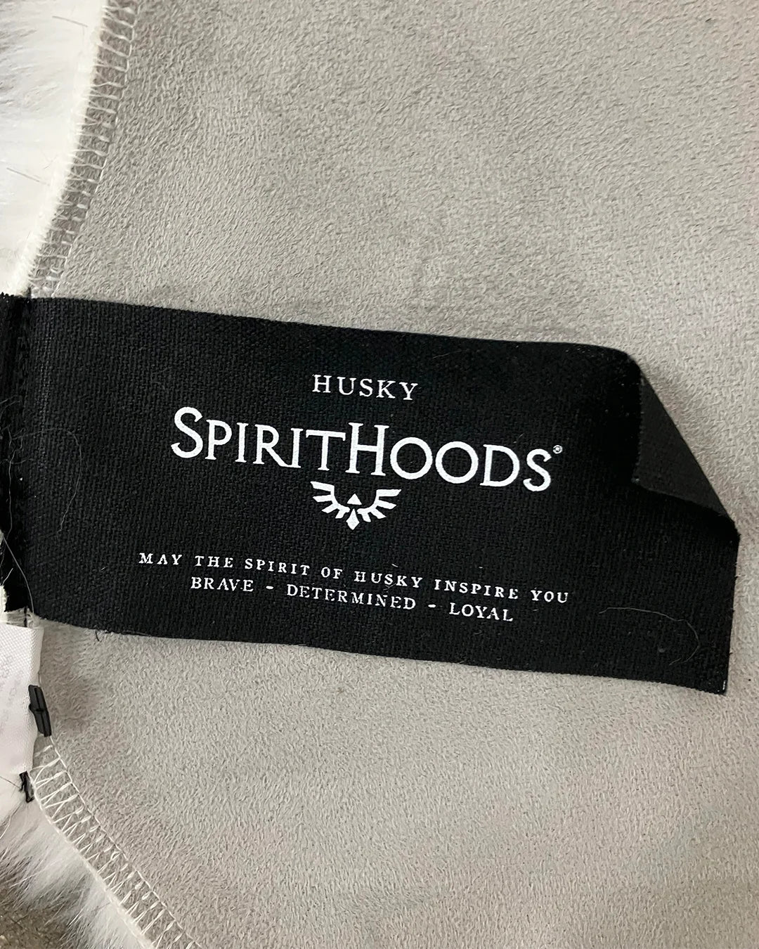 Husky Spirithoods label on a product on the gray suede husky rug backing