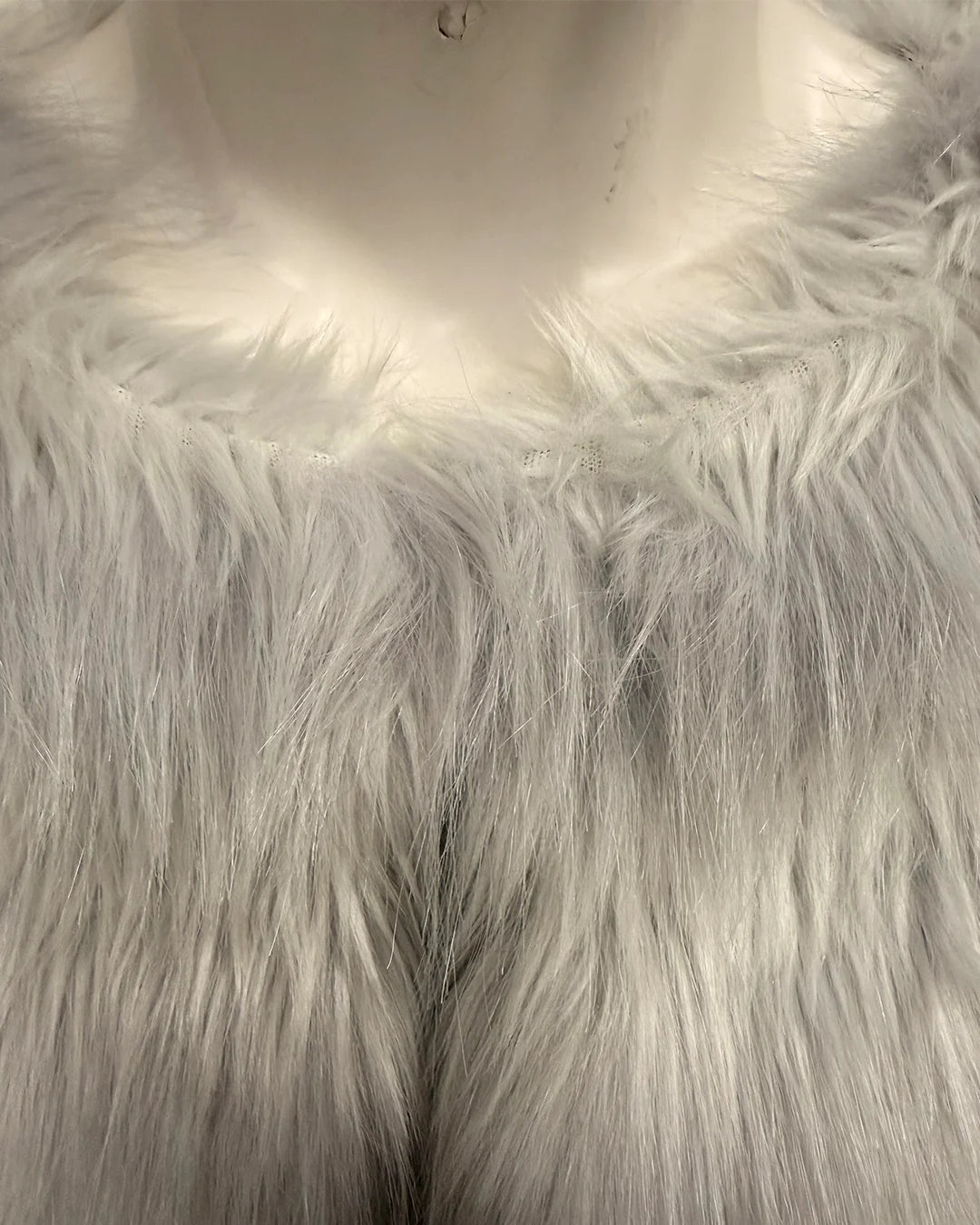 Close-up of a white/silver faux fur garment on a mannequin