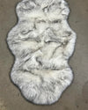 white faux fur with black tips, creating a husky inspired faux fur fur rug on a concrete floor