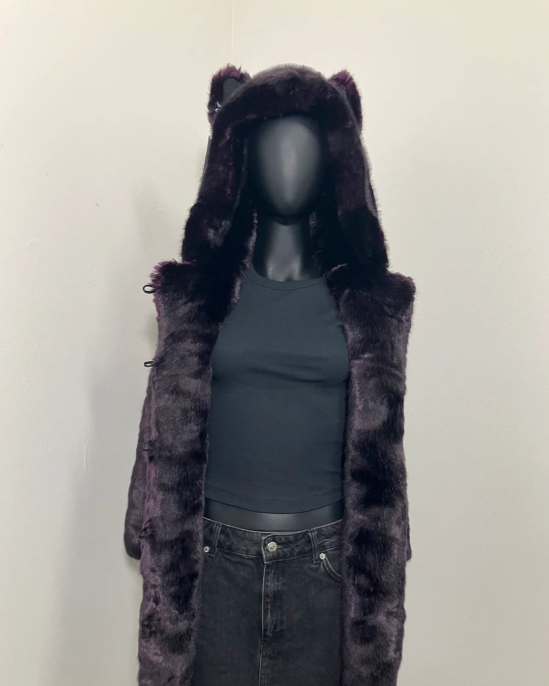 Purple fake fur coat with hood and wolf ears on a mannequin against a white background
